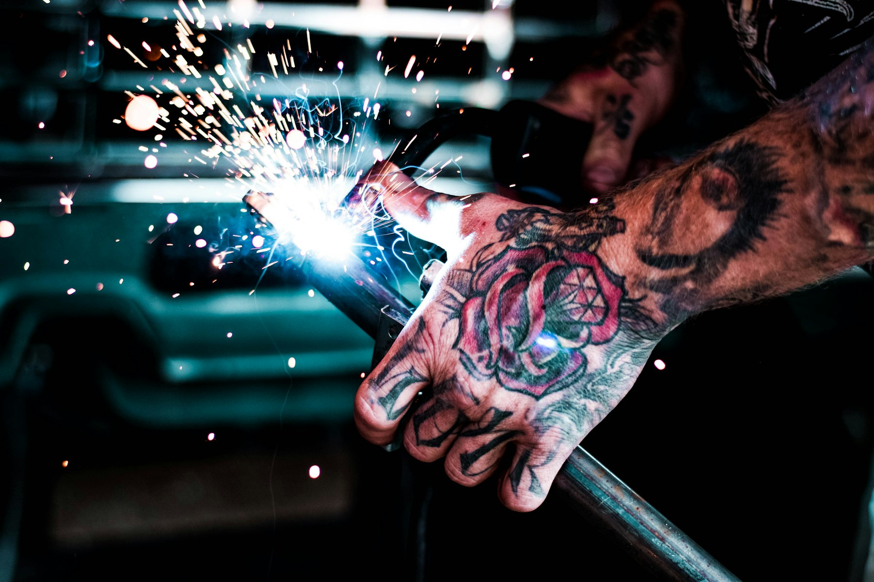A welder works on a metal component, representing Copper Creek Manufacturing's precision fabrication floor